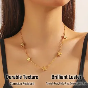 Close-up detail of a gold-plated stainless steel flower chain necklace on a model