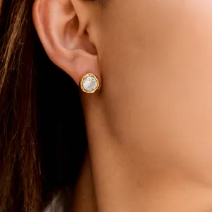 Detailed view of a gold titanium steel stud earring featuring a brilliant clear crystal.