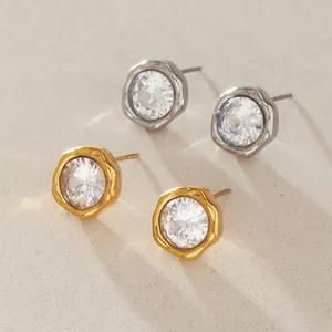Close-up of gold and silver stainless steel stud earrings with large round crystals.