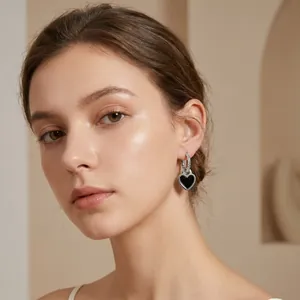 Gros plan de boucles d'oreilles cœur en émail noir avec anneau argenté sur un mannequin