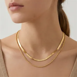 Détail du collier double rang en acier doré avec maille serpent et chaîne torsadée