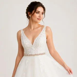 Close-up of elegant bridal belt with hand-sewn rhinestones and pearls on a white wedding dress.