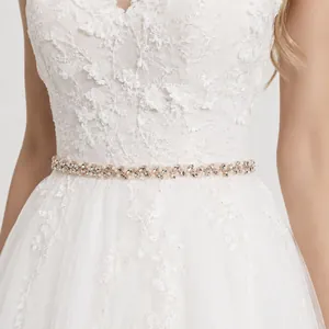 Elegant bridal sash with hand-stitched rhinestones and pearls on white wedding gown detail