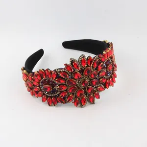Close-up of a wide Baroque headband featuring intricate red rhinestone flower patterns.
