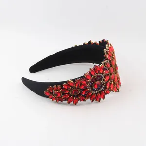 Detailed view of red rhinestone floral patterns on a Baroque-style wide black headband.