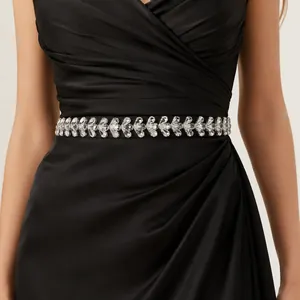 Close-up of elegant handmade rhinestone bridal belt with leaf pattern on black dress