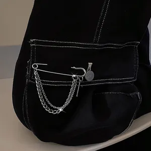 Detailed close-up of a silver alloy paperclip brooch with stylish layered hanging chains