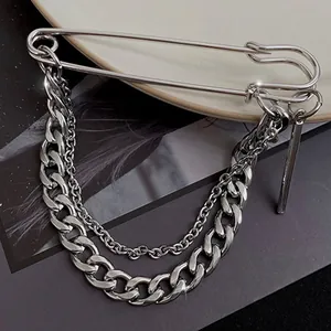 Macro view of a silver alloy safety pin brooch with double layered curb chains decoration.