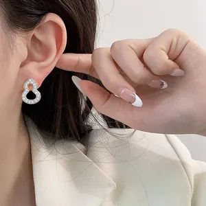Silver gourd-shaped stud earrings with pavé crystals on Asian female model