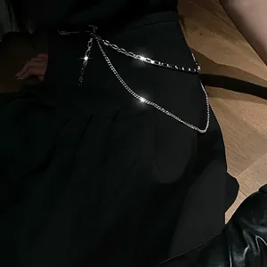 Detailed macro shot of hip-hop silver multi-layer waist chain brooch on black streetwear