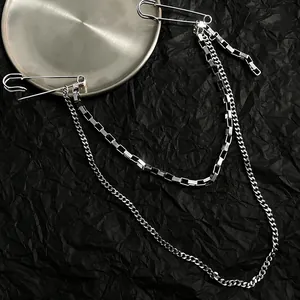 Detailed close-up of a silver double-layered hip-hop chain brooch featuring large safety pins