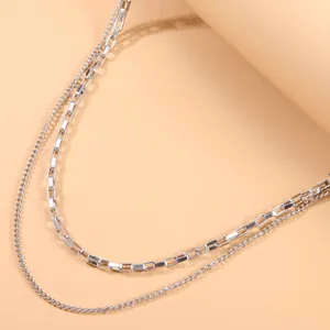 Detailed macro view of a stylish double-layer silver chain brooch with polished links