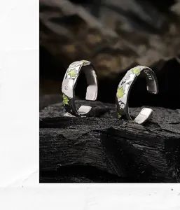 Détail de boucles d'oreilles irrégulières en argent 925 avec émail vert et zircons