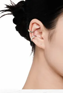 Gros plan d'un ear cuff en argent de forme irrégulière avec émail coloré sur l'oreille