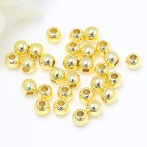 Primo piano di perline distanziatrici rotonde lisce riempite d'oro 14K per creare gioielli