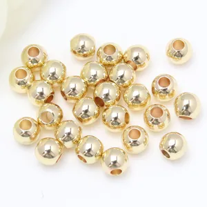 Dettaglio di perle tonde lisce in oro 14K per la creazione di gioielli fai-da-te
