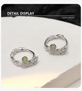 Close-up of S925 silver flower hoop earrings with heteromorphic texture and green stones