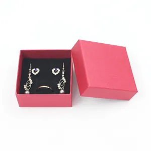 Detailed view of red textured jewelry box with black velvet interior holding jewelry set.
