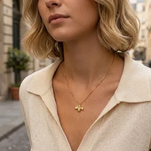 Close-up of cute 18K gold-plated bee pendant necklace worn by female model outdoors.