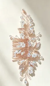 Macro detail of handmade bridal hair comb featuring delicate pearls and crystal leaf patterns