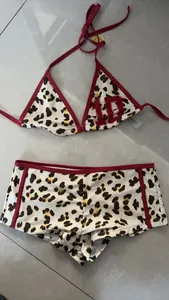 Detailed view of leopard print two-piece bikini set with red trim and boy leg shorts