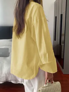 Detailed back view of a yellow long-sleeved casual blouse featuring textured fabric.