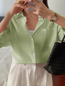 Detail view of a stylish casual light green linen button-up shirt for women with pocket.