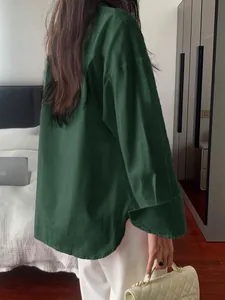 Close-up detail of a textured dark green long-sleeved shirt for women in a casual style