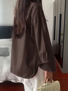 Side back view of a casual brown long-sleeved blouse for women in a lifestyle setting.