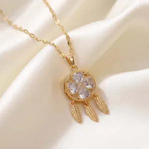 Collana acchiappasogni dorata con zirconi a cuore su sfondo di seta bianca elegante.