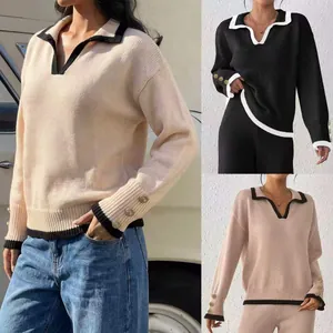 Detail view of women's knit sweaters showing contrast trim and decorative gold cuff buttons