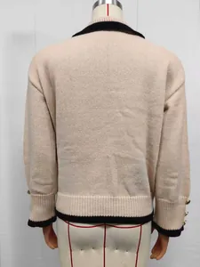 Back view of women's beige knit sweater with black contrast trim and gold buttons