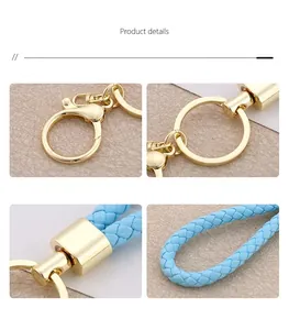 Detail view showing gold lobster clasp and blue braided leather cord of the keychain