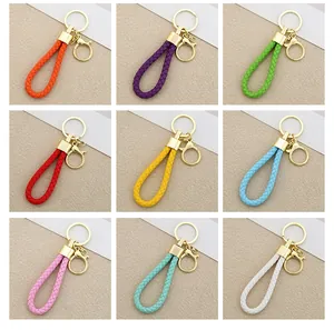 Detailed view of colorful handmade woven leather car keychains in a nine-grid layout.