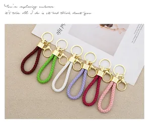 Collection of colorful braided leather keychains with stylish gold-tone metal hardware.