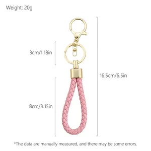 Pink hand-woven leather rope keychain with gold hardware and detailed product dimensions