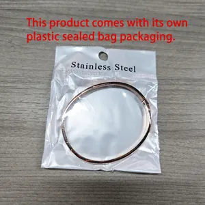 Detailed macro view of a minimalist rose gold stainless steel bangle in polybag packaging