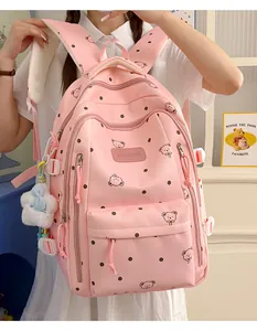 Gros plan d'un sac à dos rose tendance avec des motifs d'ours et des pois blancs