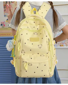 Vue détaillée du sac à dos jaune à pois avec motifs d'ours et le logo Vavabag