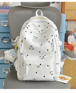 Détail d'un sac à dos blanc à pois avec motif d'ours mignon et logo Vavabag en gros plan