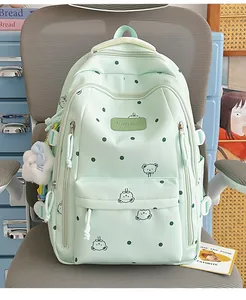 Vue détaillée du sac à dos vert menthe à pois avec motifs ours et porte-clés en peluche blanc