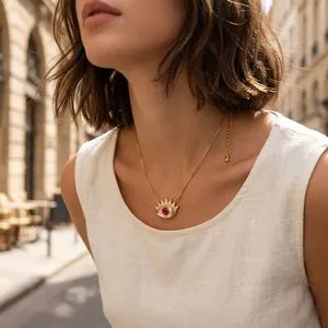 Detailed view of a gold-plated evil eye necklace with zircon sun eye pendant on a model