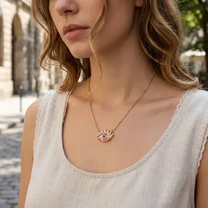 Detail view of gold-plated evil eye necklace with zircon sun pendant on model woman.