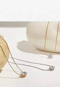 Detailed view of three minimalist titanium steel necklaces with sparkling hexagonal zircons.