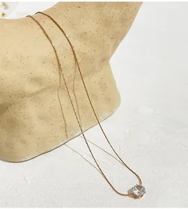 Close-up of rose gold stainless steel necklace with a sparkling round zircon pendant