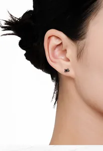 Detailed close-up showing a cute black S925 sterling silver cat stud earring on a model's ear