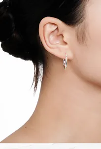 Detailed view of a polished S925 sterling silver Mobius twist hoop earring worn on an ear.