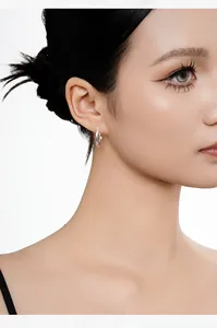 Detailed view of minimalist S925 sterling silver Mobius hoop earring worn by a model