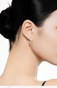 Side view detail of a polished S925 sterling silver Mobius twisted hoop earring on ear