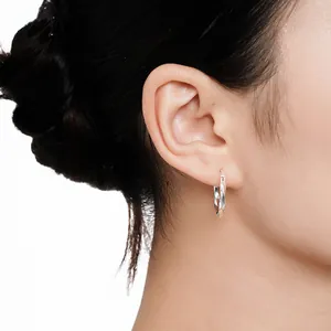 S925 sterling silver Mobius hoop earrings worn by a model in a close-up profile view